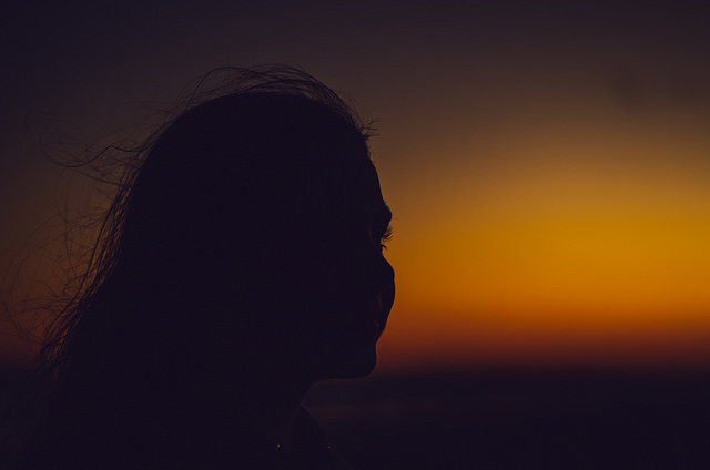 A shadowed profile of a girl on a beach
